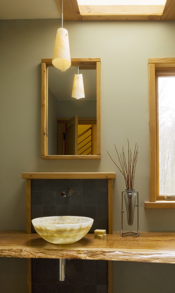 На фото: ванная комната в стиле рустика с настольной раковиной, столешницей из дерева, серой плиткой, каменной плиткой и зелеными стенами