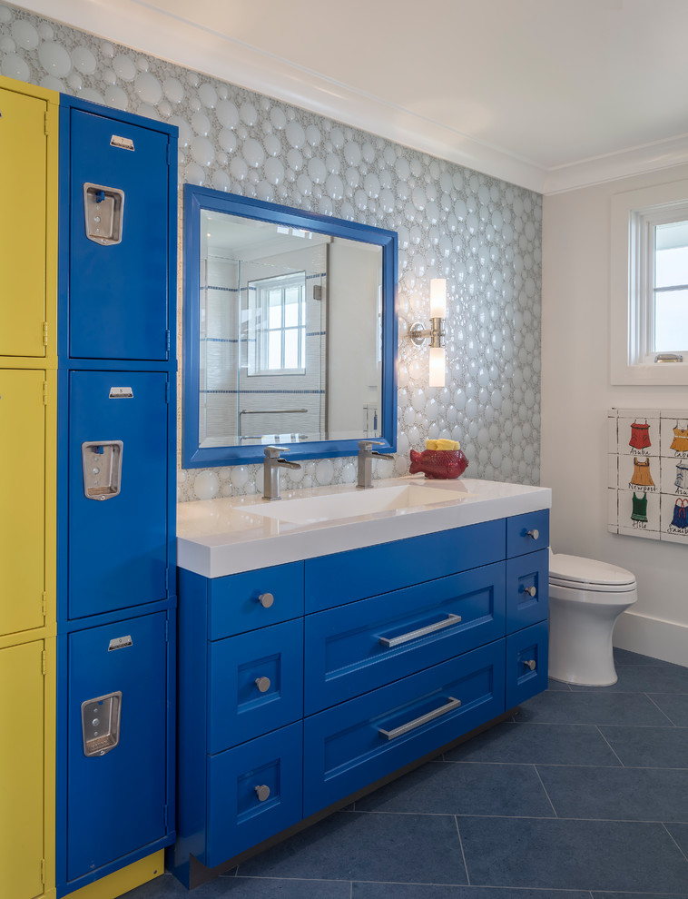 Réalisation d'une salle de bain marine avec un placard avec porte à panneau encastré, des portes de placard bleues, un carrelage gris, un carrelage en pâte de verre, un mur blanc, une grande vasque, un sol bleu et un plan de toilette blanc.