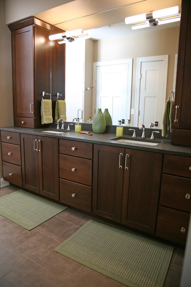 Elegant porcelain tile bathroom photo in Milwaukee with an undermount sink, recessed-panel cabinets and dark wood cabinets