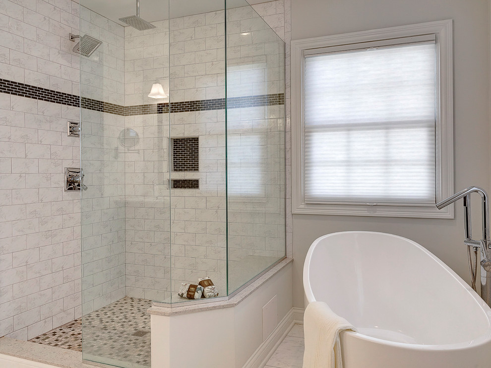 Modern inredning av ett badrum, med luckor med infälld panel, skåp i mörkt trä, marmorbänkskiva, ett fristående badkar, en hörndusch, vit kakel och tunnelbanekakel