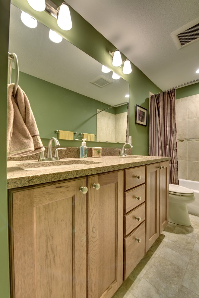 Réalisation d'une salle de bain craftsman en bois clair de taille moyenne avec un lavabo posé, un placard avec porte à panneau encastré, un plan de toilette en granite, une baignoire en alcôve, une douche d'angle, un carrelage beige, des carreaux de céramique et un mur vert.