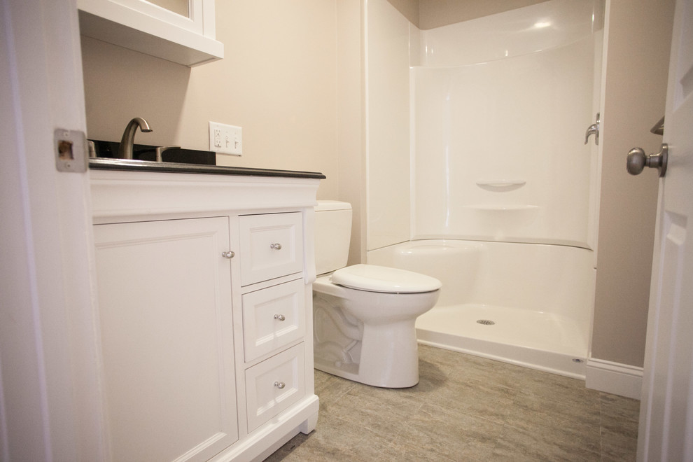 Klassisches Badezimmer mit Schrankfronten mit vertiefter Füllung, weißen Schränken, Duschnische, Toilette mit Aufsatzspülkasten, beigen Fliesen, beiger Wandfarbe und Unterbauwaschbecken in Portland Maine