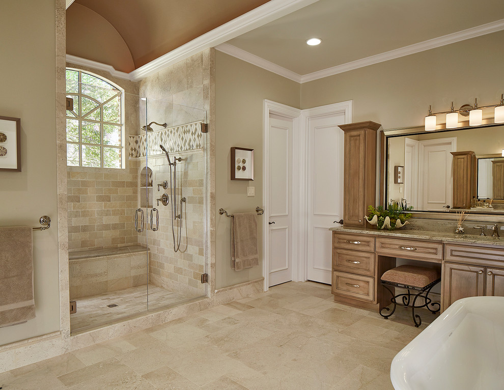 Immagine di una grande stanza da bagno chic con vasca freestanding, pavimento in pietra calcarea e top in granito