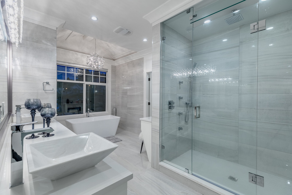 Идея дизайна: большая главная ванная комната в современном стиле с фасадами в стиле шейкер, белыми фасадами, отдельно стоящей ванной, душем в нише, белой плиткой, мраморной плиткой, белыми стенами, мраморным полом, настольной раковиной, столешницей из искусственного камня, белым полом и душем с распашными дверями