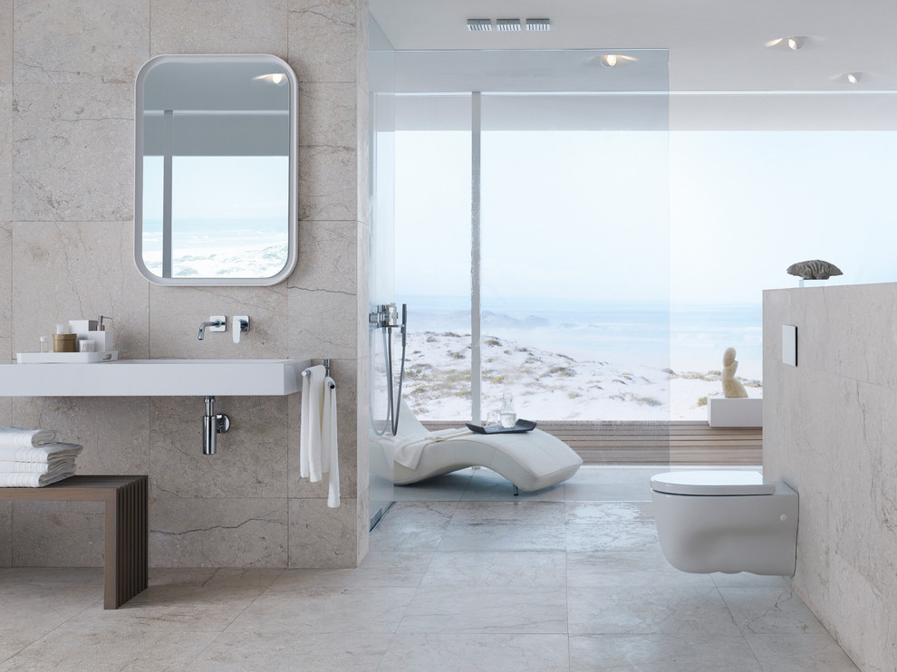 Exempel på ett mellanstort modernt en-suite badrum, med ett väggmonterat handfat, marmorbänkskiva, en vägghängd toalettstol, beige kakel, stenkakel och beige väggar