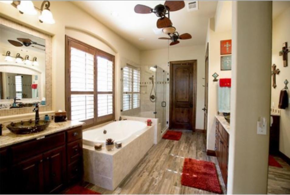 Cette photo montre une grande salle de bain principale sud-ouest américain en bois foncé avec une vasque, un placard avec porte à panneau surélevé, un plan de toilette en granite, une baignoire posée, une douche d'angle, un carrelage beige, des carreaux de céramique, un mur beige et parquet foncé.