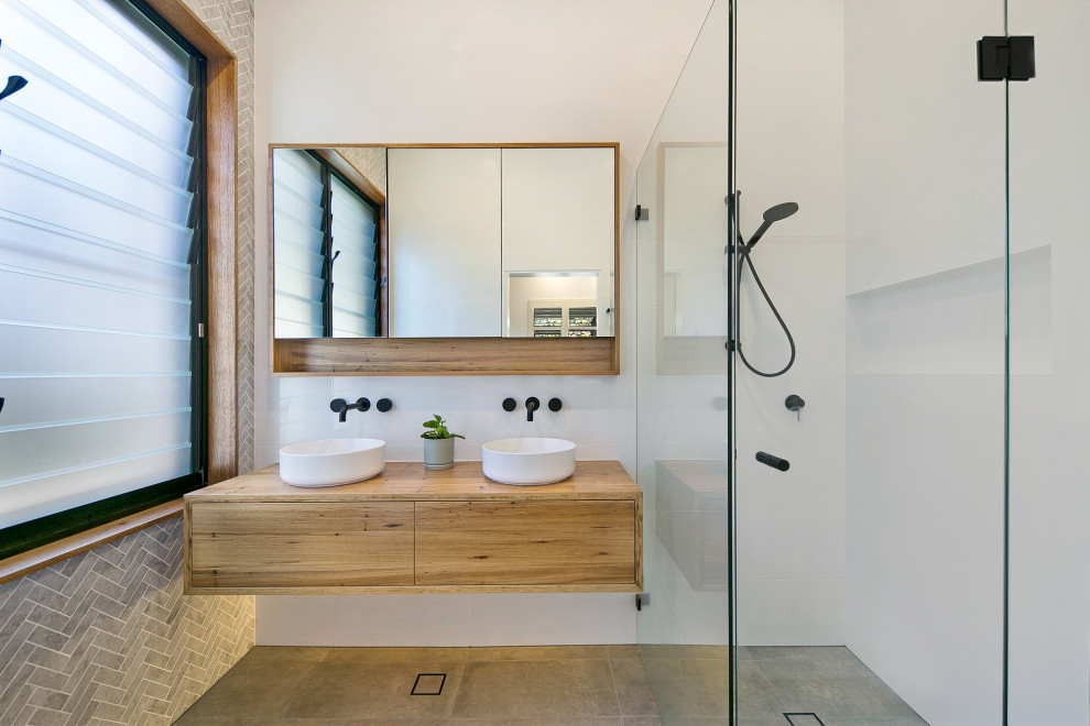 Example of a large trendy master white tile ceramic tile, double-sink and gray floor bathroom design in Sydney with wood countertops, a floating vanity, flat-panel cabinets, medium tone wood cabinets, a vessel sink, brown countertops and a niche