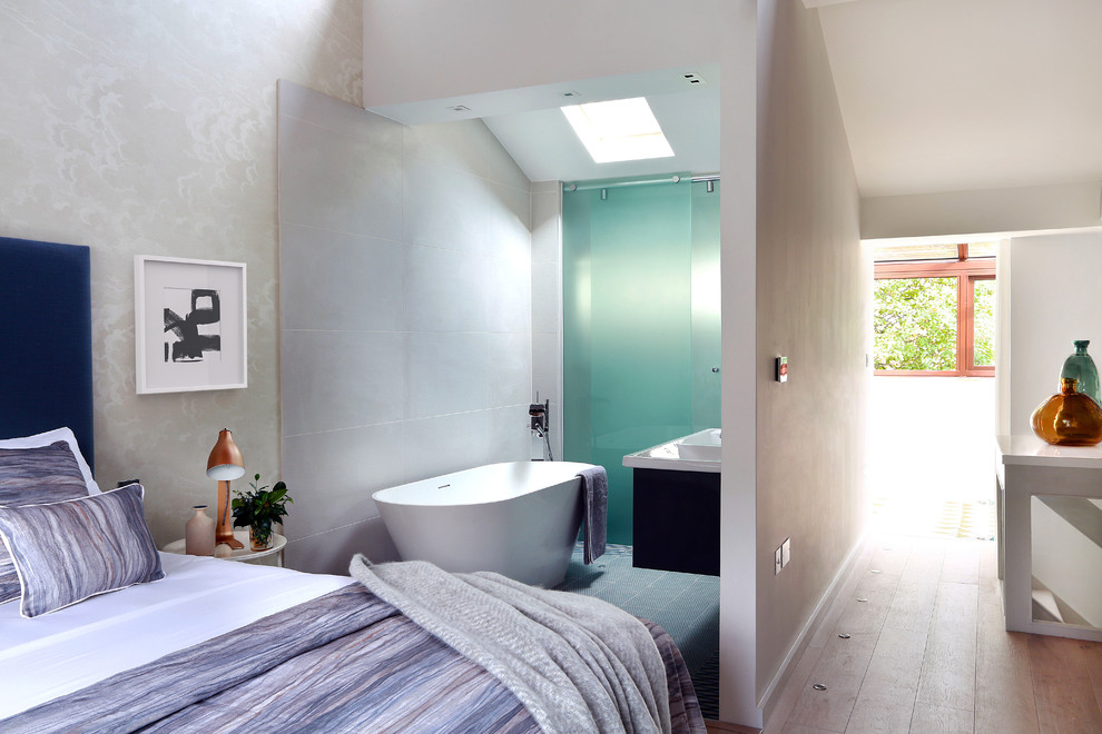 Idée de décoration pour une grande salle de bain principale design avec un placard en trompe-l'oeil, des portes de placard bleues, une baignoire indépendante, un carrelage bleu, des carreaux de porcelaine, un mur gris, un sol en carrelage de porcelaine et un lavabo suspendu.