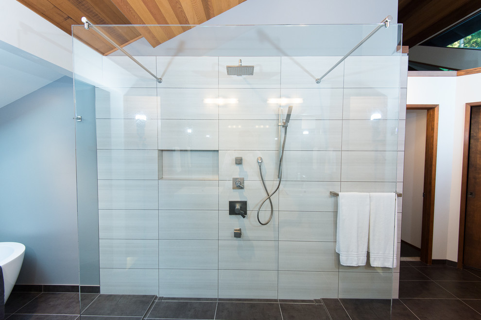 Пример оригинального дизайна: большая главная ванная комната в стиле модернизм с серой плиткой, керамогранитной плиткой, серыми стенами, полом из керамогранита, отдельно стоящей ванной и открытым душем