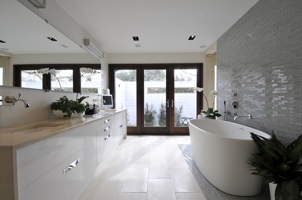 Ispirazione per una stanza da bagno padronale moderna con lavabo integrato, ante lisce, vasca freestanding, piastrelle blu, pareti bianche e ante bianche