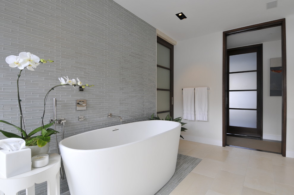 Immagine di una stanza da bagno padronale moderna con vasca freestanding, piastrelle blu, pareti bianche, lavabo integrato e ante lisce