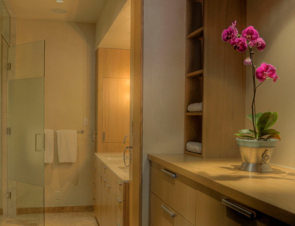 Exemple d'une petite salle de bain principale en bois clair avec un lavabo encastré, un placard à porte plane, un plan de toilette en quartz modifié, une douche d'angle, WC à poser, un carrelage beige, un carrelage de pierre, un mur blanc et un sol en calcaire.