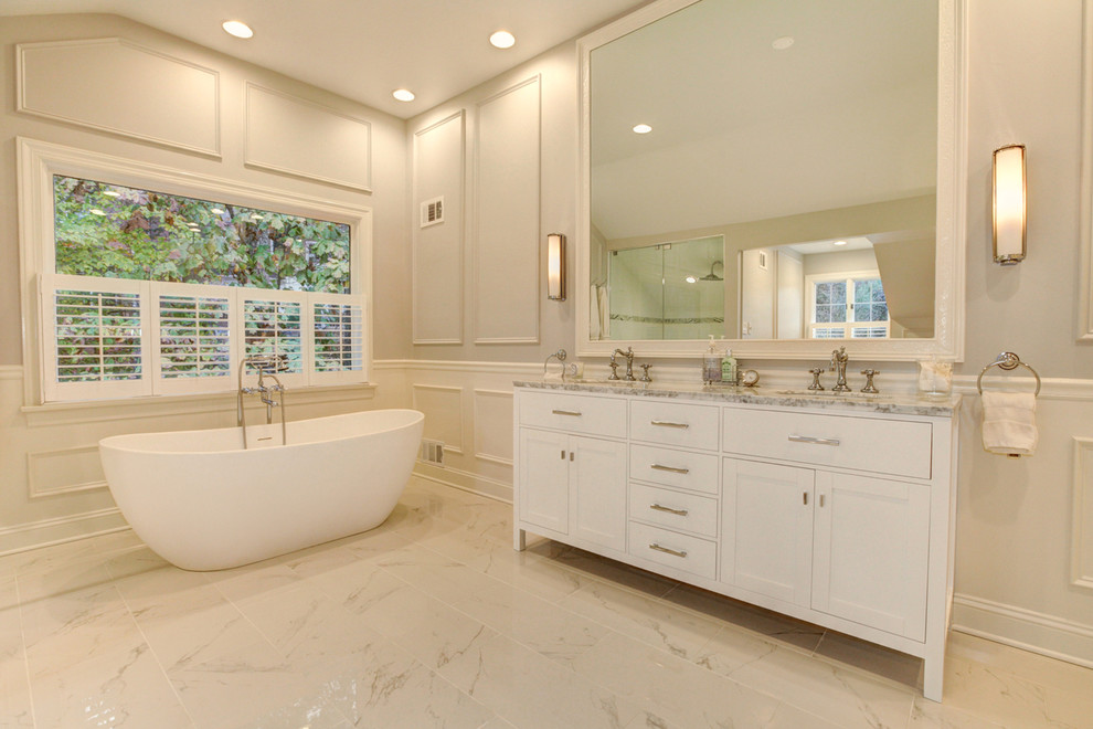Foto di una stanza da bagno chic con ante in stile shaker, ante bianche, vasca freestanding e pareti grigie