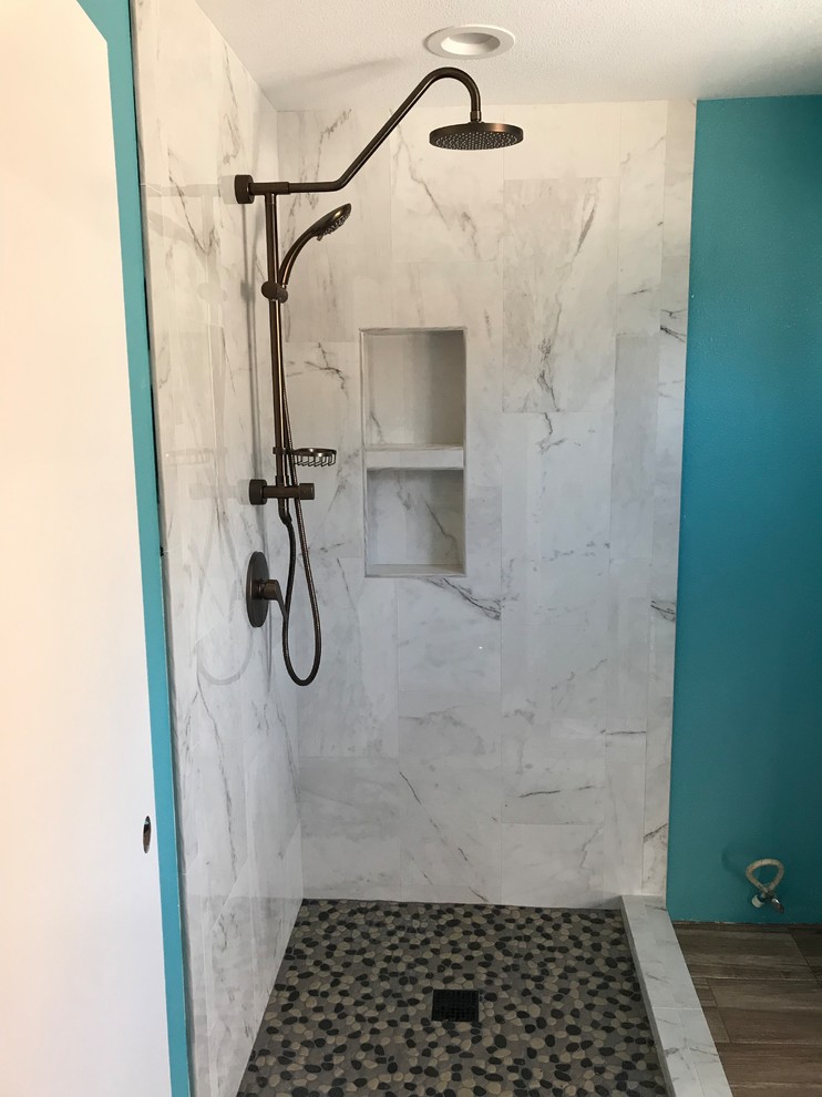 Large contemporary ensuite bathroom in Orange County with shaker cabinets, medium wood cabinets, a corner shower, a two-piece toilet, white tiles, ceramic tiles, blue walls, ceramic flooring, a submerged sink, engineered stone worktops, brown floors, a hinged door and white worktops.