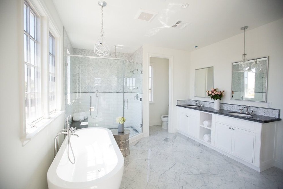 Пример оригинального дизайна: большая главная ванная комната в классическом стиле с отдельно стоящей ванной, угловым душем, белой плиткой, керамогранитной плиткой, белыми стенами, мраморным полом и мраморной столешницей