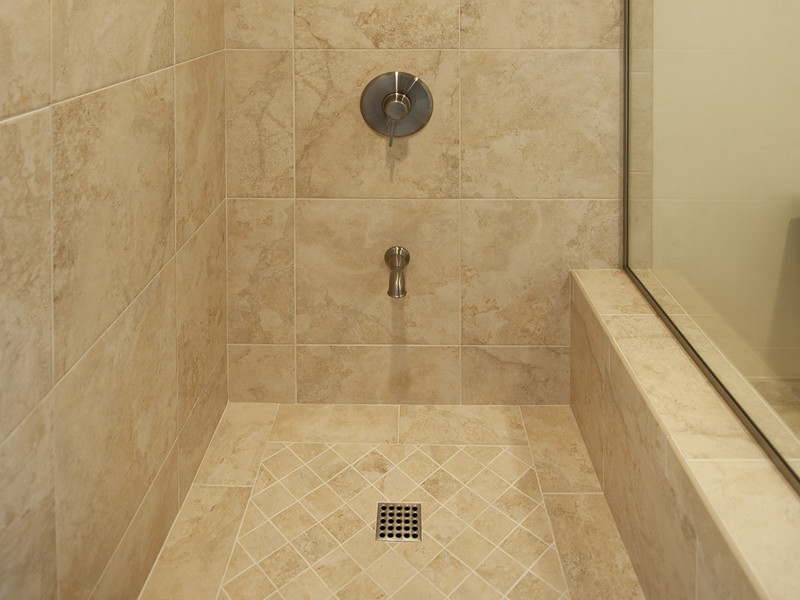 Foto på ett stort funkis en-suite badrum, med en kantlös dusch, en toalettstol med separat cisternkåpa, beige kakel, porslinskakel, beige väggar och klinkergolv i porslin