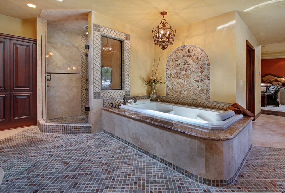 Expansive mediterranean ensuite bathroom in Orange County with freestanding cabinets, dark wood cabinets, a hot tub, a corner shower, multi-coloured tiles, mosaic tiles, beige walls, porcelain flooring, a submerged sink and granite worktops.
