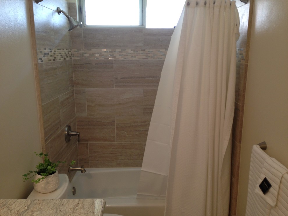 Inredning av ett klassiskt litet badrum med dusch, med granitbänkskiva, ett badkar i en alkov, en dusch/badkar-kombination, en toalettstol med separat cisternkåpa, flerfärgad kakel, porslinskakel, beige väggar, klinkergolv i porslin, luckor med upphöjd panel, vita skåp, ett undermonterad handfat och dusch med duschdraperi