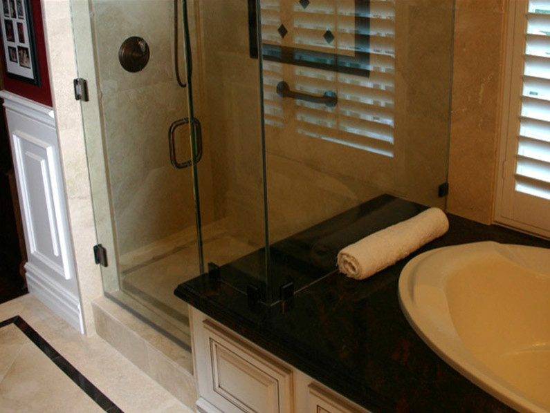 Idee per una stanza da bagno padronale minimal con ante con bugna sagomata, ante bianche, vasca da incasso, doccia ad angolo, WC monopezzo, pareti rosse, pavimento in marmo, lavabo sottopiano e top in granito