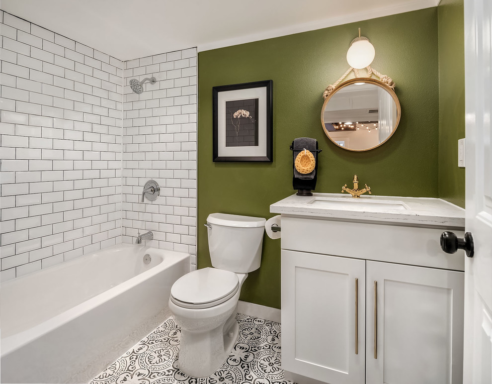 Klassisk inredning av ett badrum med dusch, med skåp i shakerstil, vita skåp, ett badkar i en alkov, en dusch/badkar-kombination, en toalettstol med separat cisternkåpa, vit kakel, tunnelbanekakel, gröna väggar, cementgolv, ett undermonterad handfat och med dusch som är öppen