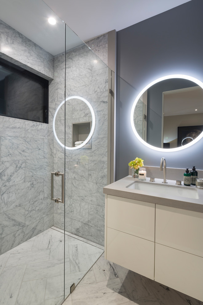 Inspiration for an expansive contemporary bathroom in San Francisco with flat-panel cabinets, beige cabinets, a two-piece toilet, marble tiles, grey walls, marble flooring, a submerged sink, concrete worktops, a hinged door and beige worktops.