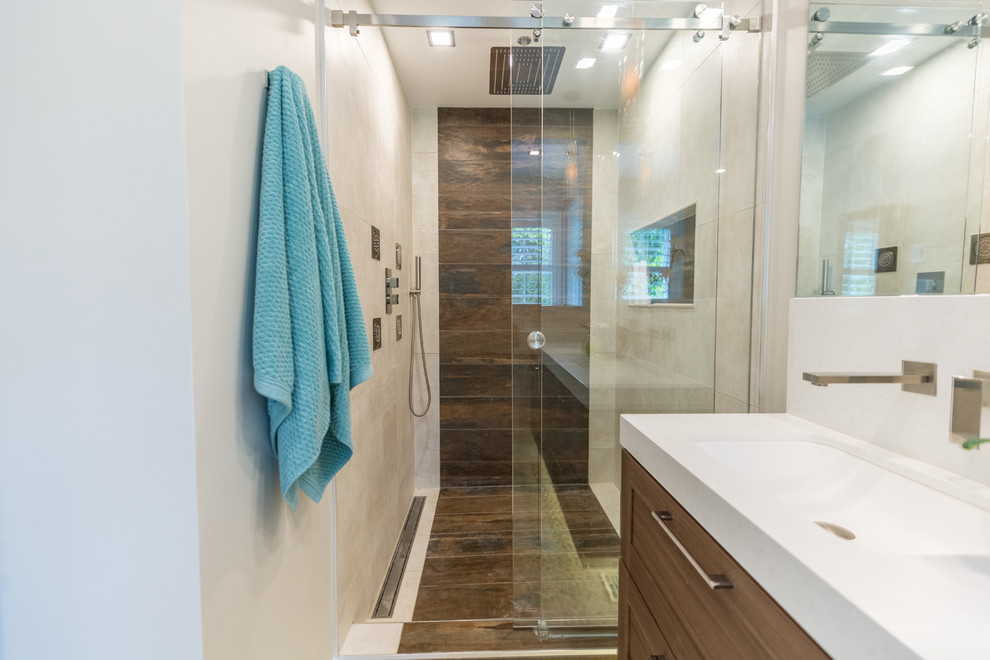 Foto di una stanza da bagno minimal con ante con riquadro incassato, ante marroni, lavabo da incasso, top in superficie solida, pavimento marrone e top bianco
