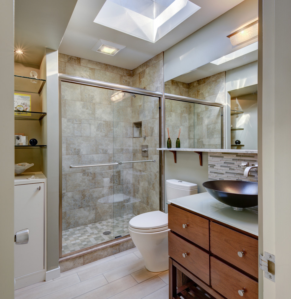 На фото: ванная комната в стиле ретро с плоскими фасадами, коричневыми фасадами, душем в нише, унитазом-моноблоком, бежевой плиткой, бежевыми стенами, душевой кабиной, настольной раковиной, стеклянной столешницей, бежевым полом, душем с раздвижными дверями и белой столешницей
