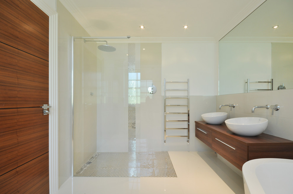 На фото: большая ванная комната в стиле модернизм с столешницей из дерева, угловым душем, белой плиткой, белыми стенами и темными деревянными фасадами с