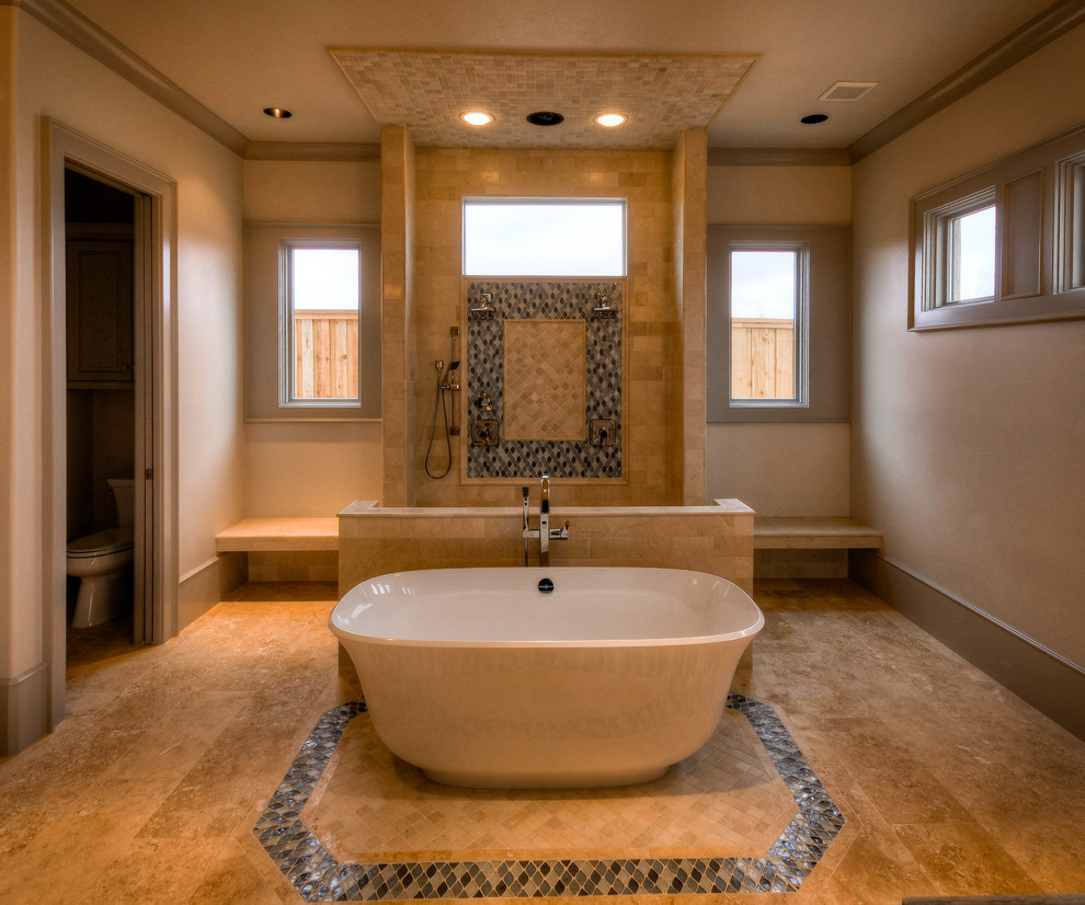 Пример оригинального дизайна: большая главная ванная комната в средиземноморском стиле с плоскими фасадами, бежевыми фасадами, отдельно стоящей ванной, открытым душем, коричневой плиткой, каменной плиткой, коричневыми стенами, полом из травертина, настольной раковиной, мраморной столешницей, коричневым полом и шторкой для ванной