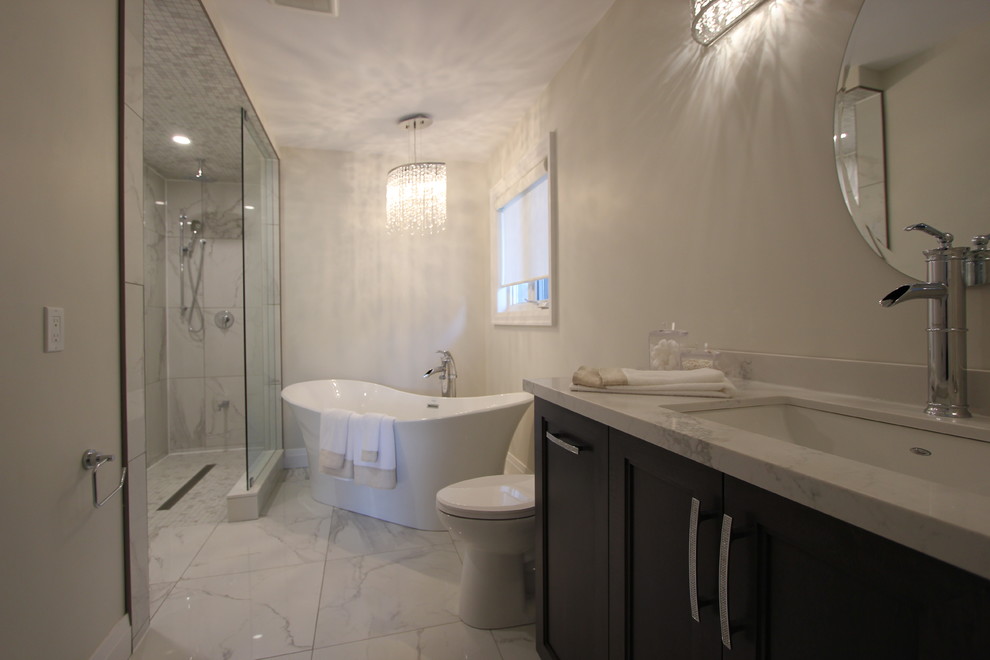 Inspiration pour une grande salle de bain principale design en bois foncé avec un placard à porte shaker, une baignoire en alcôve, une douche à l'italienne, WC à poser, un carrelage gris, des carreaux de porcelaine, un mur gris, un sol en carrelage de porcelaine, un lavabo encastré, un plan de toilette en quartz, un sol blanc et aucune cabine.