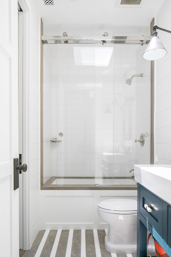 Example of a mid-sized island style kids' white tile and subway tile bathroom design in Orange County with shaker cabinets, blue cabinets, white walls, an integrated sink and white countertops