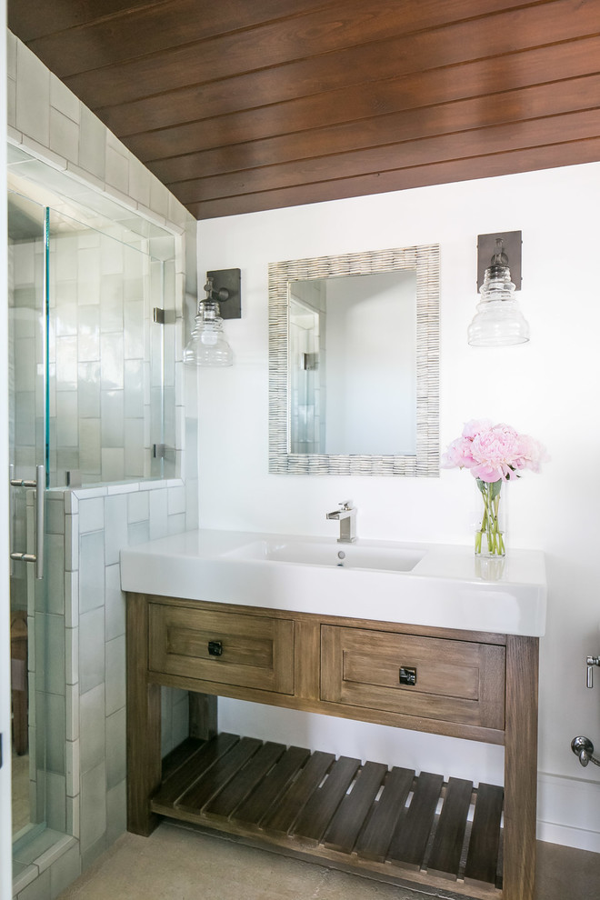 Island style alcove shower photo in Orange County with shaker cabinets, medium tone wood cabinets, white walls, an integrated sink and white countertops