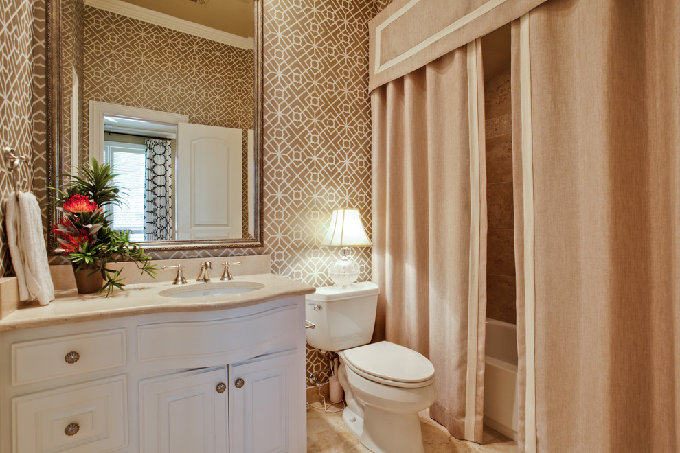ダラスにあるトラディショナルスタイルのおしゃれな浴室 (アンダーカウンター洗面器、レイズドパネル扉のキャビネット、白いキャビネット、アルコーブ型浴槽、シャワー付き浴槽	、分離型トイレ) の写真