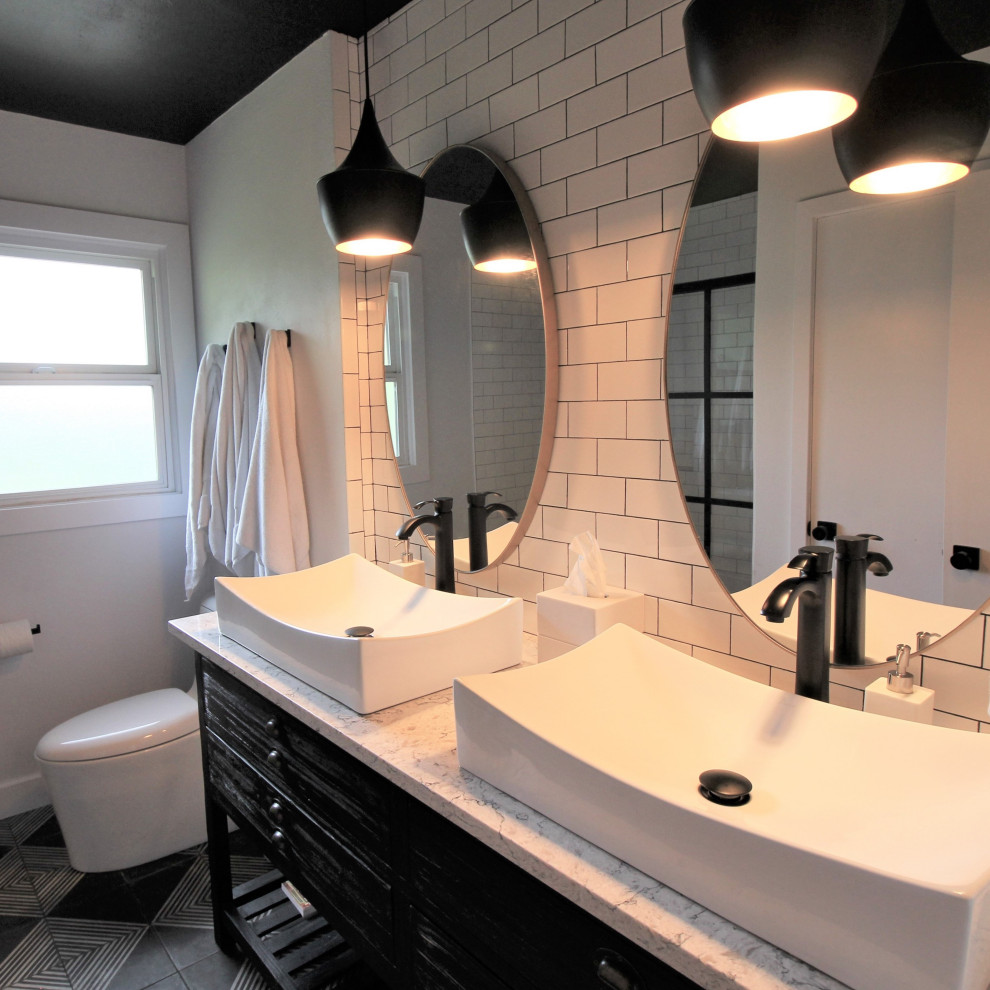 Идея дизайна: маленькая детская ванная комната в стиле неоклассика (современная классика) с черными фасадами, ванной в нише, душем над ванной, унитазом-моноблоком, белой плиткой, плиткой кабанчик, белыми стенами, полом из керамической плитки, настольной раковиной, столешницей из искусственного кварца, черным полом, разноцветной столешницей, тумбой под две раковины и напольной тумбой для на участке и в саду