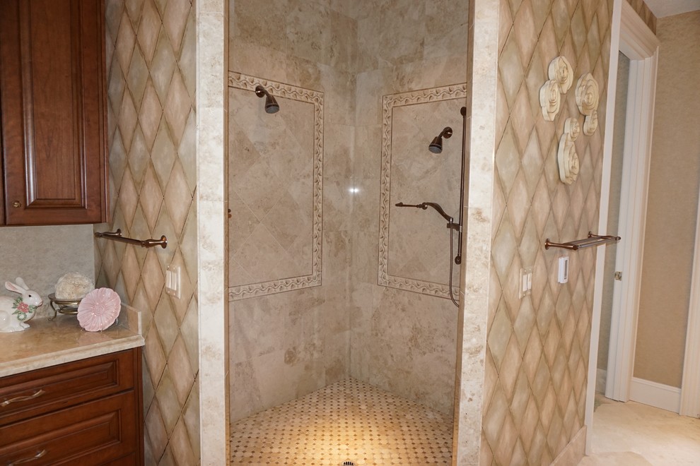 Exempel på ett stort klassiskt en-suite badrum, med luckor med upphöjd panel, skåp i mellenmörkt trä, en jacuzzi, en kantlös dusch, en toalettstol med separat cisternkåpa, beige kakel, stenkakel, bruna väggar, travertin golv, ett undermonterad handfat och granitbänkskiva