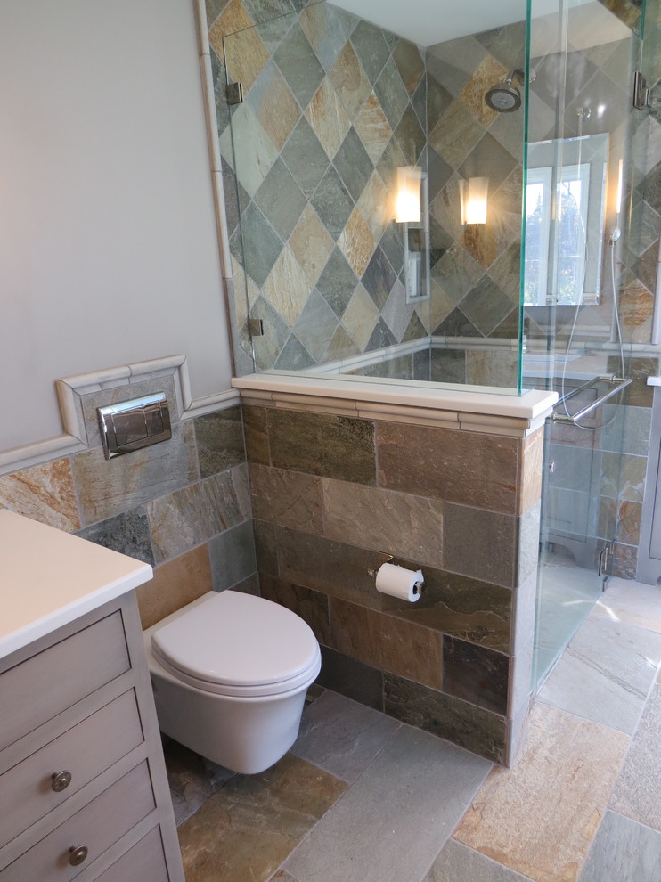 Inspiration for a mid-sized coastal master multicolored tile and stone tile pebble tile floor bathroom remodel in Portland Maine with furniture-like cabinets, gray cabinets, a wall-mount toilet, multicolored walls, an undermount sink and quartz countertops