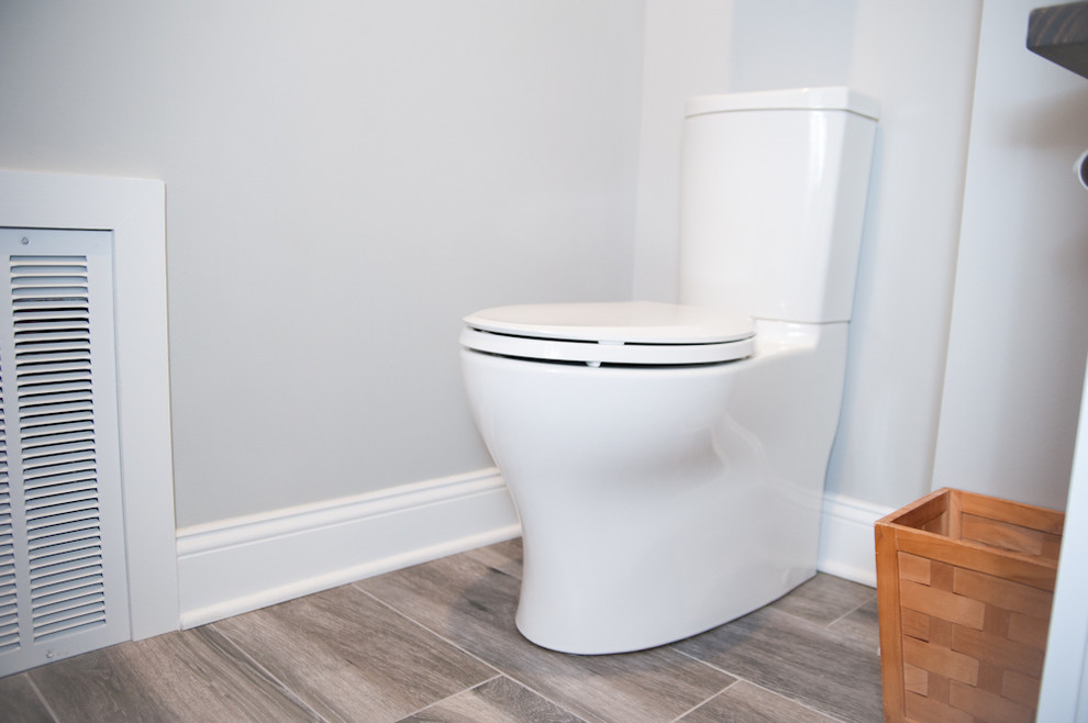 Foto de cuarto de baño actual pequeño con lavabo sobreencimera, encimera de madera, sanitario de una pieza, paredes grises, suelo de madera en tonos medios y aseo y ducha