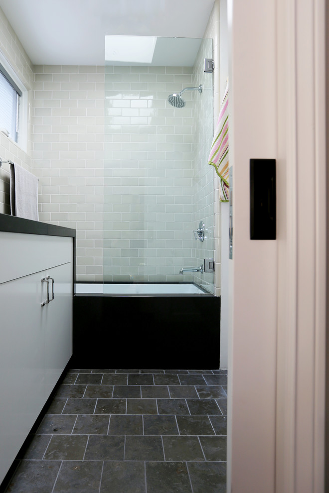 Example of a mid-sized urban 3/4 beige tile and ceramic tile limestone floor corner shower design in San Diego with flat-panel cabinets, gray cabinets, marble countertops, an undermount tub, a two-piece toilet, an undermount sink and white walls