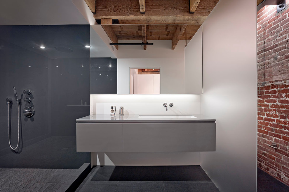 Mid-sized urban master black tile and porcelain tile porcelain tile doorless shower photo in San Francisco with an undermount sink, flat-panel cabinets, gray cabinets, glass countertops, a wall-mount toilet and white walls