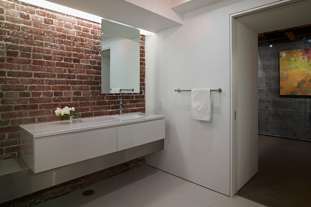 Idéer för mellanstora industriella en-suite badrum, med ett undermonterad handfat, släta luckor, bänkskiva i glas, ett japanskt badkar, porslinskakel, vita väggar, klinkergolv i porslin, grå skåp, en öppen dusch, en vägghängd toalettstol och svart kakel