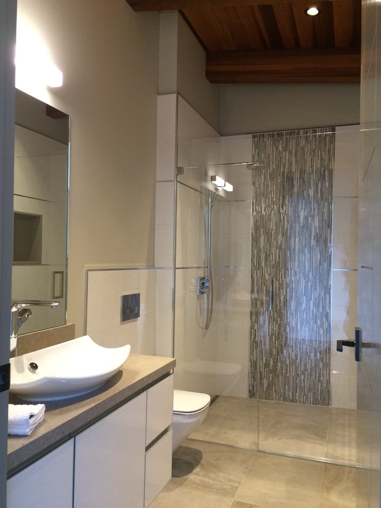 Inspiration for a mid-sized modern gray tile and porcelain tile porcelain tile walk-in shower remodel in San Francisco with flat-panel cabinets, a wall-mount toilet, beige walls and a vessel sink