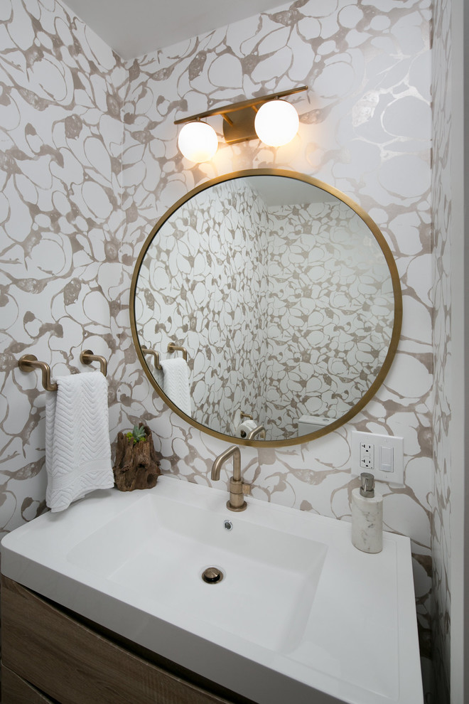 Kleines Mid-Century Badezimmer mit flächenbündigen Schrankfronten, hellbraunen Holzschränken, Toilette mit Aufsatzspülkasten, farbigen Fliesen, bunten Wänden, hellem Holzboden, Wandwaschbecken, Mineralwerkstoff-Waschtisch und weißem Boden in San Francisco