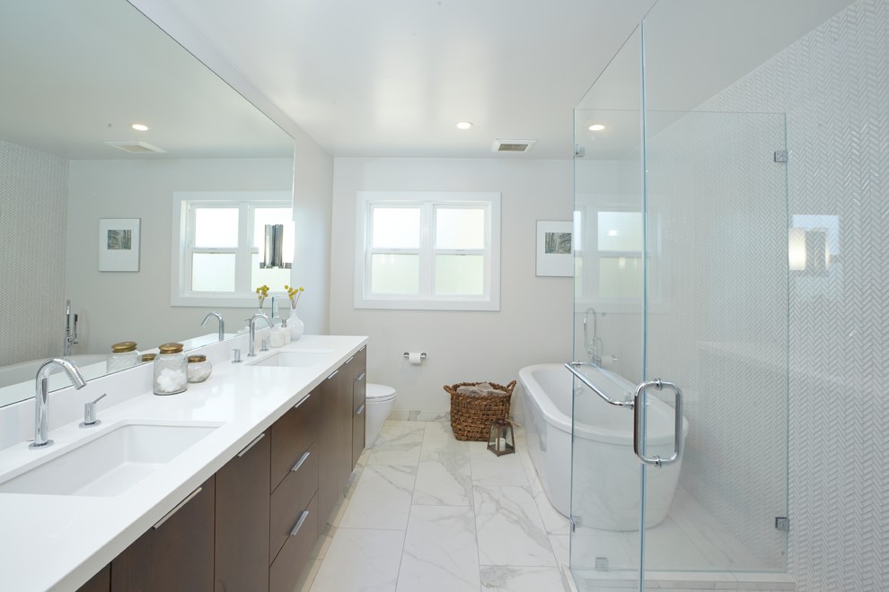 This is an example of a medium sized retro ensuite bathroom in San Francisco with flat-panel cabinets, dark wood cabinets, a freestanding bath, a built-in shower, a one-piece toilet, white tiles, mosaic tiles, white walls, marble flooring, a submerged sink and engineered stone worktops.