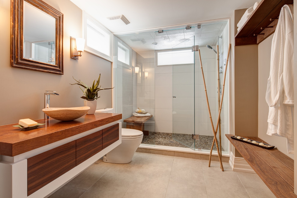 Diseño de cuarto de baño asiático con lavabo sobreencimera, encimera de madera, encimeras marrones y ventanas