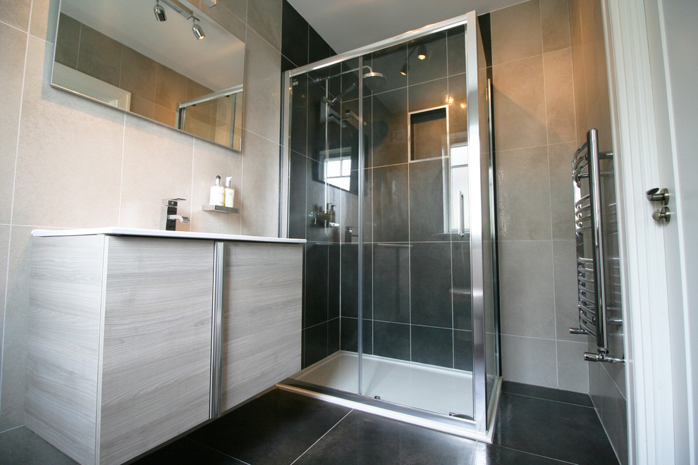 Mittelgroßes Modernes Badezimmer mit verzierten Schränken, hellen Holzschränken, Eckdusche, Toilette mit Aufsatzspülkasten, grauen Fliesen, Porzellanfliesen, grauer Wandfarbe und Porzellan-Bodenfliesen in Dublin