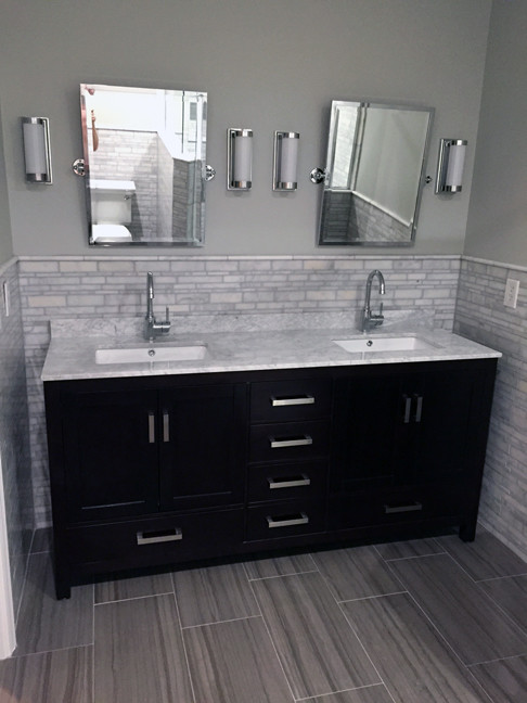 Modern inredning av ett litet en-suite badrum, med ett undermonterad handfat, möbel-liknande, svarta skåp, marmorbänkskiva, grå kakel, stenkakel, grå väggar och klinkergolv i porslin