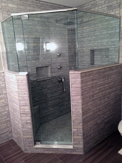 Cette photo montre une petite salle de bain principale moderne avec une douche d'angle, un carrelage gris, un carrelage de pierre, un mur gris et un sol en carrelage de porcelaine.