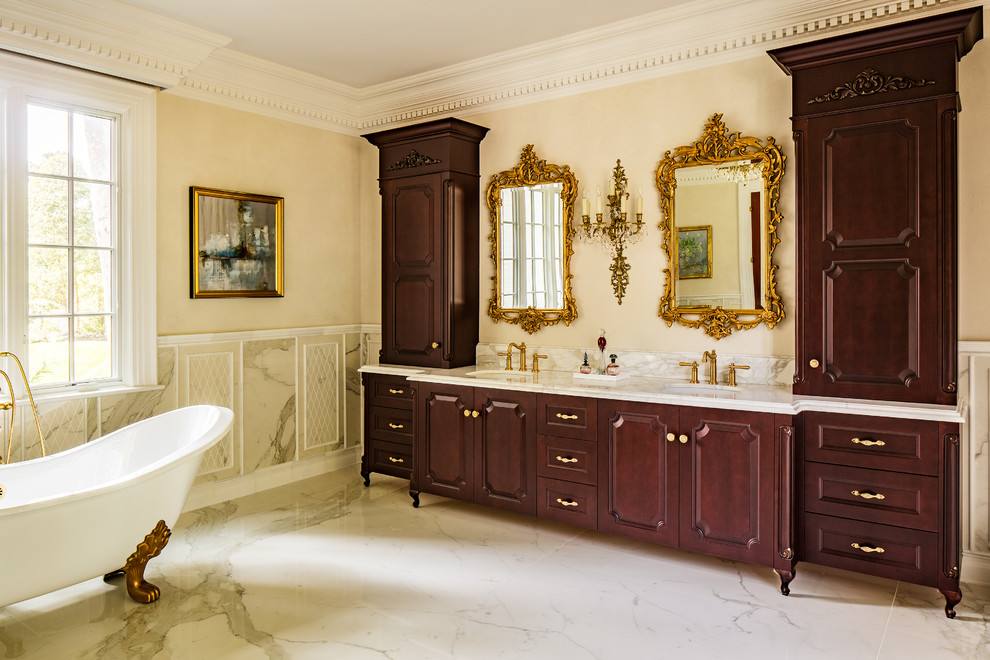 На фото: главная ванная комната в классическом стиле с фасадами островного типа, темными деревянными фасадами и ванной на ножках
