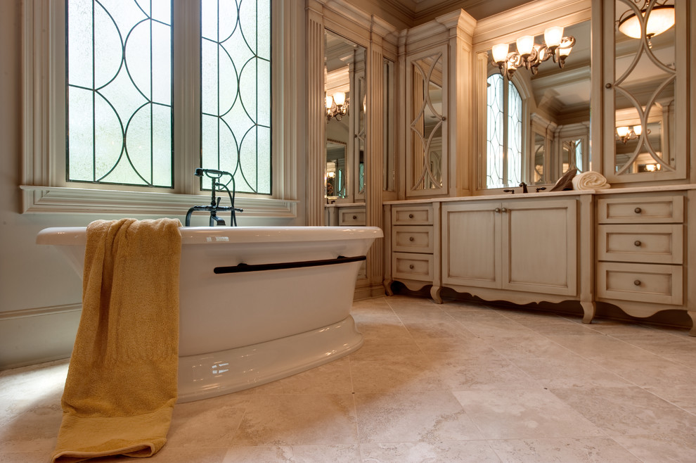 Modelo de cuarto de baño clásico con armarios con rebordes decorativos y bañera exenta