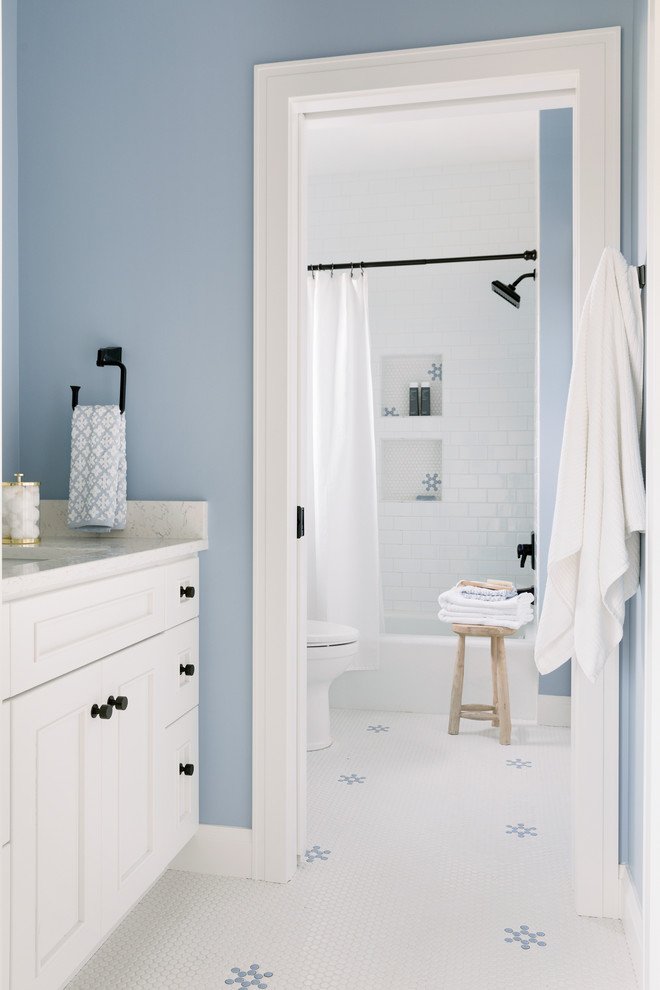 Inredning av ett maritimt stort badrum för barn, med vita skåp, ett badkar i en alkov, en dusch/badkar-kombination, en toalettstol med hel cisternkåpa, tunnelbanekakel, mosaikgolv, ett undermonterad handfat, marmorbänkskiva, vitt golv, dusch med duschdraperi, vit kakel och blå väggar